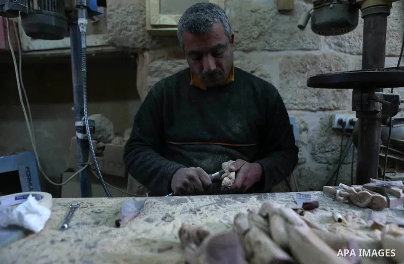 A Palestinian carpenter carves a wooden effigies of the the Holy Family at a workshop in the West Bank town of Bethlehem, on December 26, 2016. The traditional birthplace of Jesus Christ prepares to celebrate Christmas....