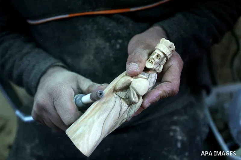 A Palestinian carpenter carves a wooden effigies of the the Holy Family at a workshop in the West Bank town of Bethlehem, on December 26, 2016. The traditional birthplace of Jesus Christ prepares to celebrate Christmas....