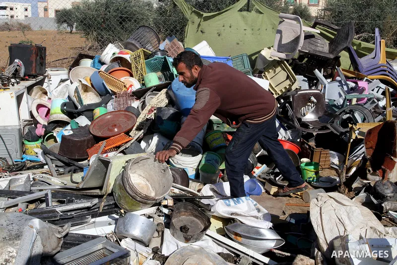 Palestinian Ziad Abu Jamea, collects his belongings outside his house which was destroyed during the 50-day war between Israel and Hamas militants in the summer of 2014, on in Khan Younis in the southern Gaza Strip Decem...
