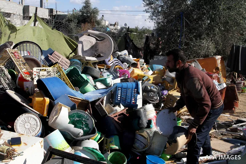 Palestinian Ziad Abu Jamea, collects his belongings outside his house which was destroyed during the 50-day war between Israel and Hamas militants in the summer of 2014, on in Khan Younis in the southern Gaza Strip Decem...