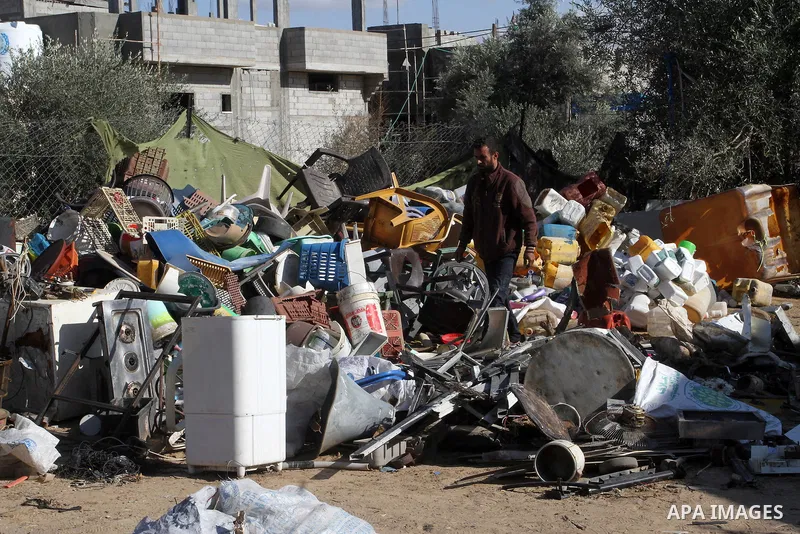 Palestinian Ziad Abu Jamea, collects his belongings outside his house which was destroyed during the 50-day war between Israel and Hamas militants in the summer of 2014, on in Khan Younis in the southern Gaza Strip Decem...
