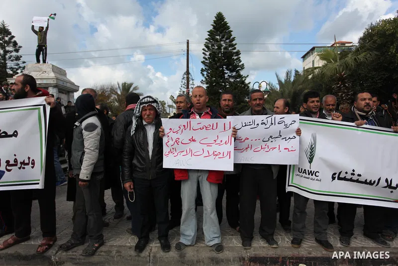 Palestinian workers shout slogans during a protest against the siege of Gaza, in Gaza City, on December 27, 2016. Photo by Ashraf Amra