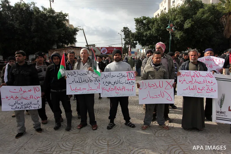 Palestinian workers shout slogans during a protest against the siege of Gaza, in Gaza City, on December 27, 2016. Photo by Ashraf Amra