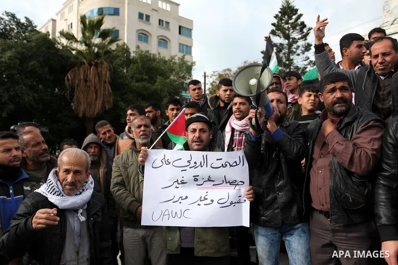 Palestinian workers shout slogans during a protest against the siege of Gaza, in Gaza City, on December 27, 2016. Photo by Ashraf Amra
