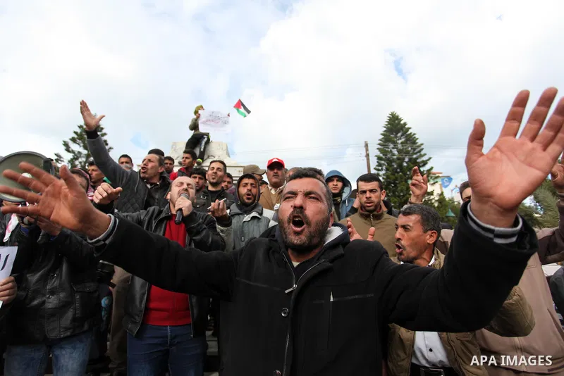 Palestinian workers shout slogans during a protest against the siege of Gaza, in Gaza City, on December 27, 2016. Photo by Ashraf Amra