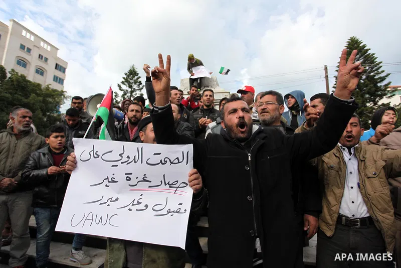 Palestinian workers shout slogans during a protest against the siege of Gaza, in Gaza City, on December 27, 2016. Photo by Ashraf Amra