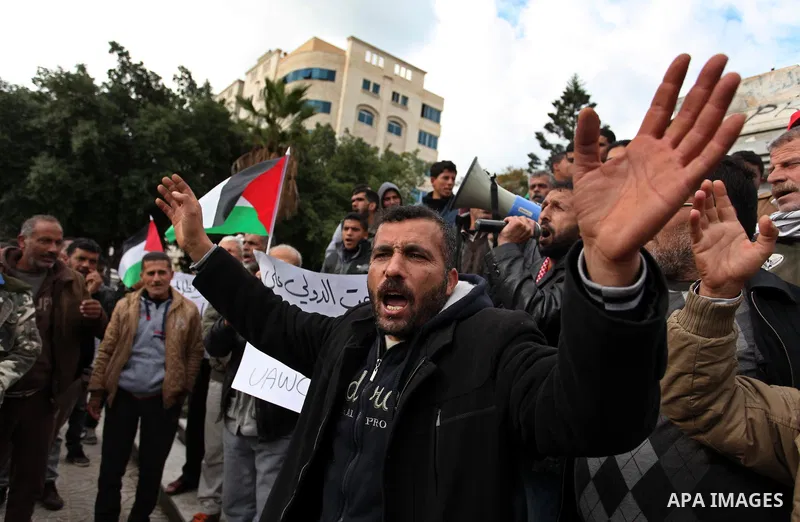 Palestinian workers shout slogans during a protest against the siege of Gaza, in Gaza City, on December 27, 2016. Photo by Ashraf Amra