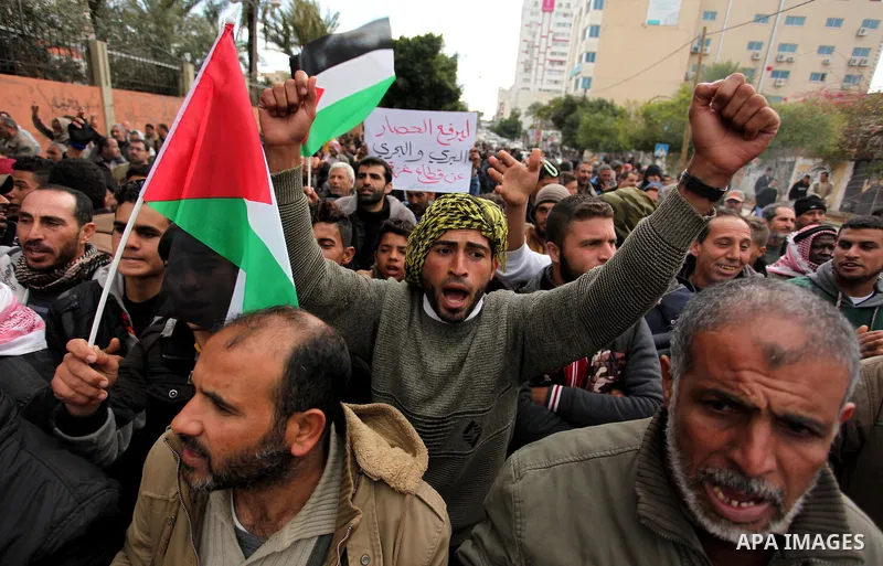 Palestinian workers shout slogans during a protest against the siege of Gaza, in Gaza City, on December 27, 2016. Photo by Ashraf Amra