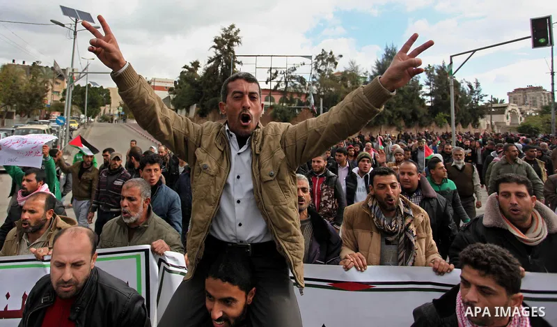 Palestinian workers shout slogans during a protest against the siege of Gaza, in Gaza City, on December 27, 2016. Photo by Ashraf Amra