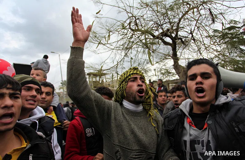 Palestinian workers shout slogans during a protest against the siege of Gaza, in Gaza City, on December 27, 2016. Photo by Ashraf Amra