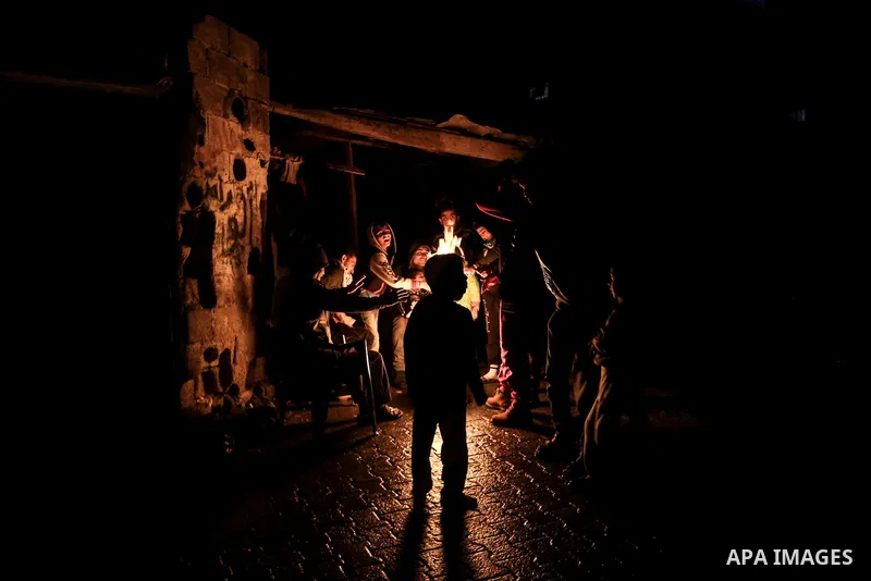 Palestinians warm themselves around a fire during the winter storm, outside their house at Al-Shate' refugee camp, in Gaza city, on December 27, 2016. Photo by Mohammed Dahman
