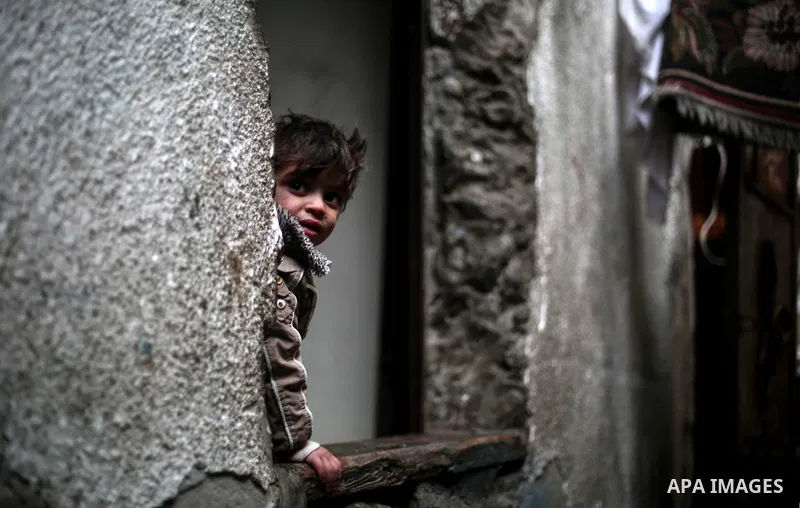 A Palestinian boy stands outside his house during the winter storm, at Al-Shate' refugee camp, in Gaza city, on December 27, 2016. Photo by Mohammed Dahman