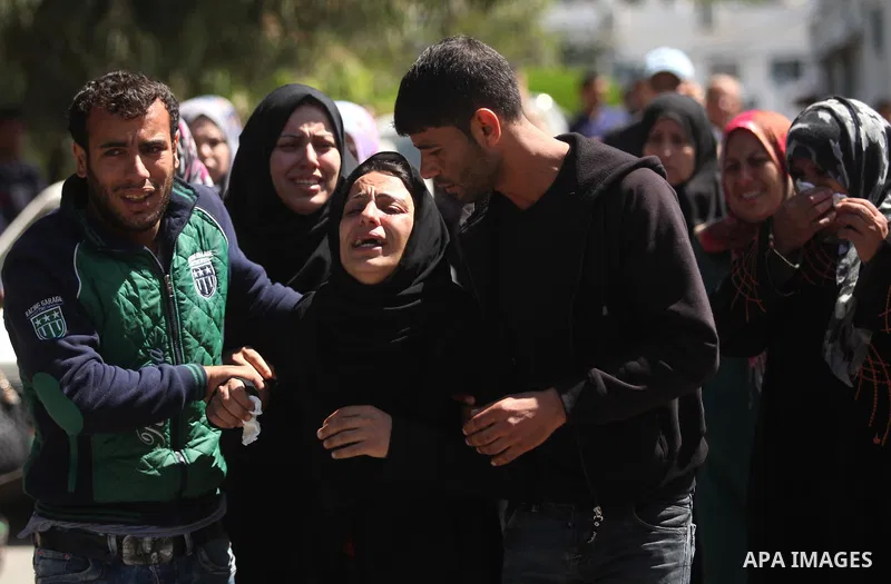The mother of the al-Hindi family mourns during the funeral of three of her sons who died in a fire caused by a candle at the family home, at the al-Shati refugee camp in Gaza City on May 7, 2016. Photo by Ashraf Amra
