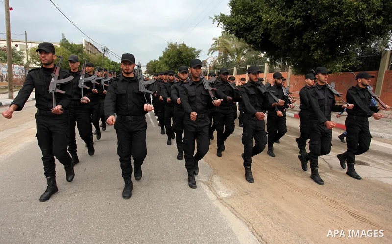 Palestinian police officers march during a rally marking the Eighth anniversary of the Israeli attack on Gaza strip in 2009, in Gaza city on December 28, 2016. Photo by Ashraf Amra