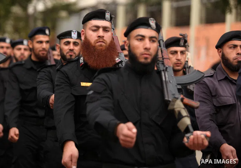 Palestinian police officers march during a rally marking the Eighth anniversary of the Israeli attack on Gaza strip in 2009, in Gaza city on December 28, 2016. Photo by Ashraf Amra