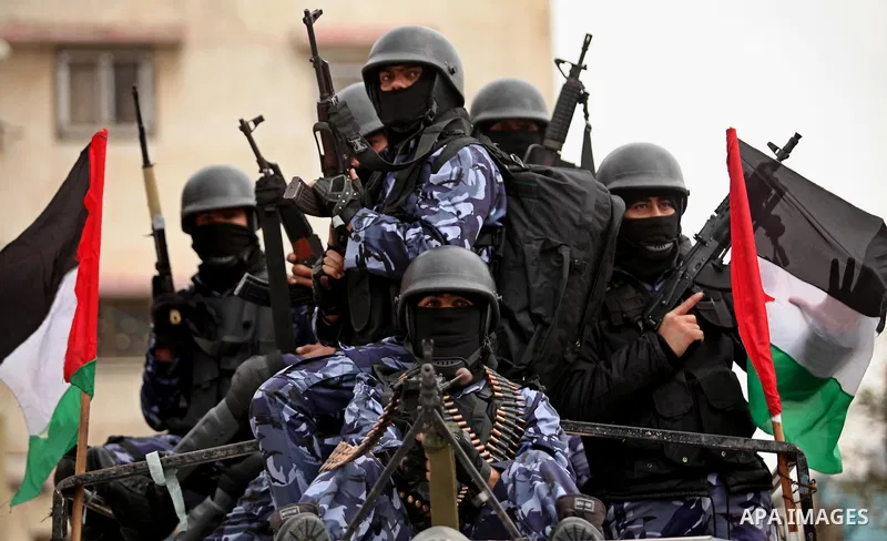 Palestinian police officers march during a rally marking the Eighth anniversary of the Israeli attack on Gaza strip in 2009, in Gaza city on December 28, 2016. Photo by Ashraf Amra