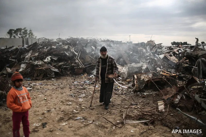 A Palestinian man walks outside his house during rainy, cold weather in a slum on the outskirts of Khan Younis refugee camp, southern Gaza Strip, on December 28, 2016. Photo by Mohammed Dahman