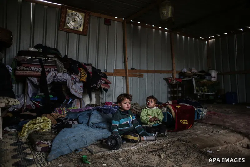 Palestinian children sit inside their family house during rainy, cold weather in a slum on the outskirts of Khan Younis refugee camp, southern Gaza Strip, Wednesday, on December 28, 2016. Photo by Mohammed Dahman
