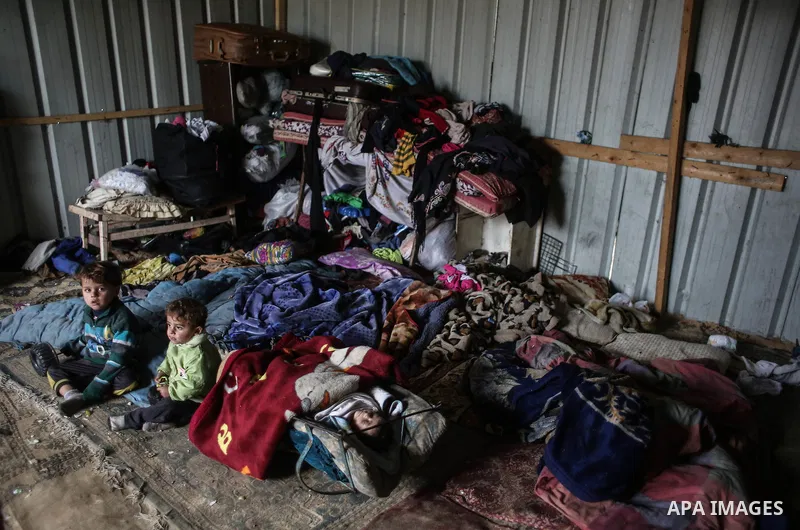 Palestinian children sit inside their family house during rainy, cold weather in a slum on the outskirts of Khan Younis refugee camp, southern Gaza Strip, Wednesday, on December 28, 2016. Photo by Mohammed Dahman