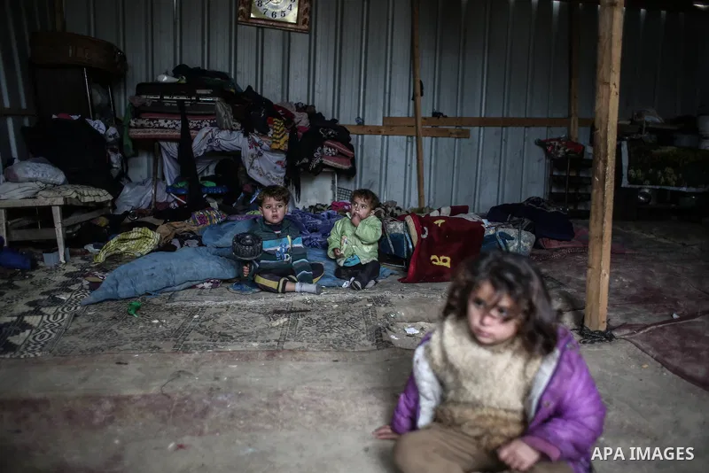 Palestinian children sit inside their family house during rainy, cold weather in a slum on the outskirts of Khan Younis refugee camp, southern Gaza Strip, Wednesday, on December 28, 2016. Photo by Mohammed Dahman