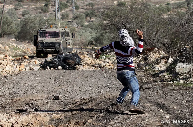 A Palestinian protester hurls stones during clashes with Israeli security forces following a demonstration against the expropriation of Palestinian land by Israel in the village of Kfar Qaddum, near Nablus, in the occupi...