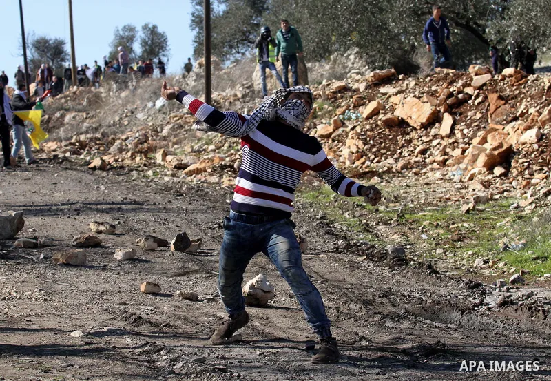 A Palestinian protester hurls stones during clashes with Israeli security forces following a demonstration against the expropriation of Palestinian land by Israel in the village of Kfar Qaddum, near Nablus, in the occupi...