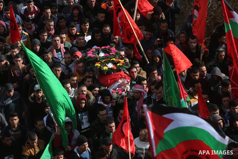 Mourners carry the body of Palestinian Maen Nasser al-Din Abu Qaraa, 23, during his funeral after Israel released his body, in the West Bank city of Ramallah, on December 31, 2016. Abu Qaraa was killed by Israeli forces...