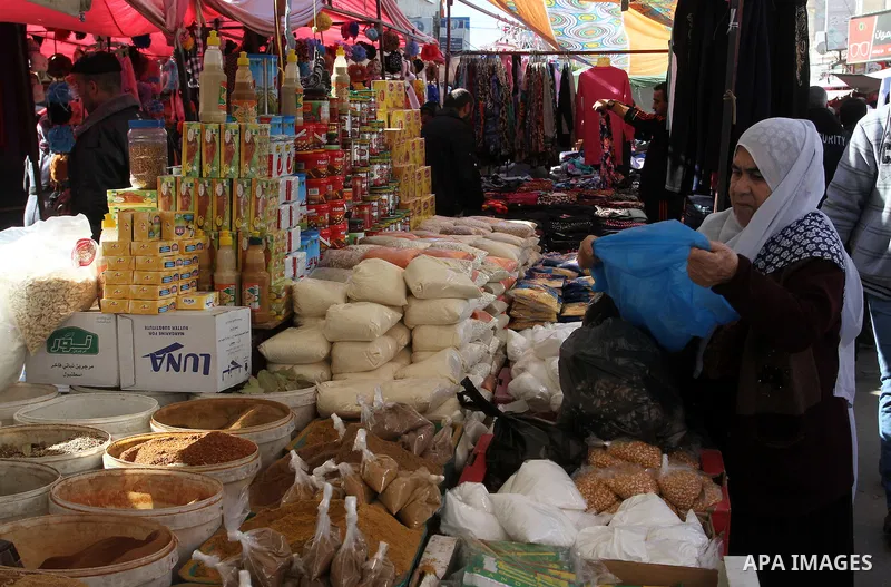 Palestinians shop at a market in Rafah in the southern of Gaza strip, on December 31, 2016. Photo by Abed Rahim Khatib