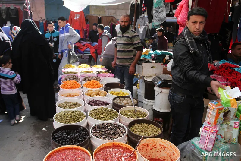 Palestinians shop at a market in Rafah in the southern of Gaza strip, on December 31, 2016. Photo by Abed Rahim Khatib