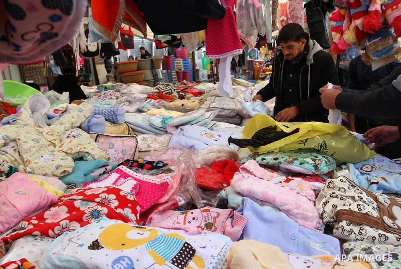 Palestinians shop at a market in Rafah in the southern of Gaza strip, on December 31, 2016. Photo by Abed Rahim Khatib