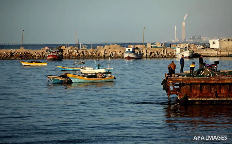 Palestinians ride a boat as they enjoy the last sunset of 2016 on the beach of Gaza City, on December 31, 2016. Photo by Ashraf Amra