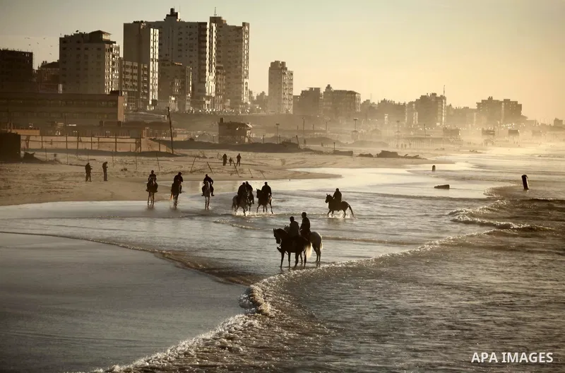 Palestinian men ride their horse as they enjoy the last sunset of 2016 at the beach of Gaza city, on the December 31, 2016. Photo by Ashraf Amra