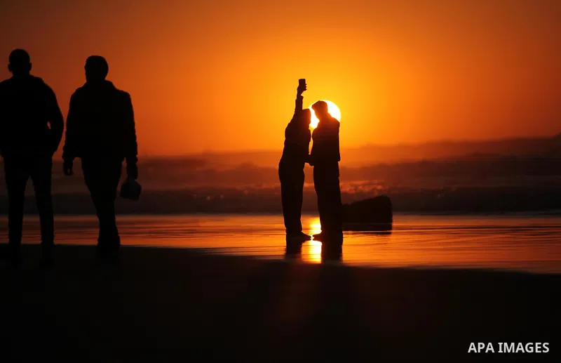 Palestinians take a selfie on the beach of Gaza City, during the last sunset of 2016, on December 31, 2016. Photo by Ashraf Amra