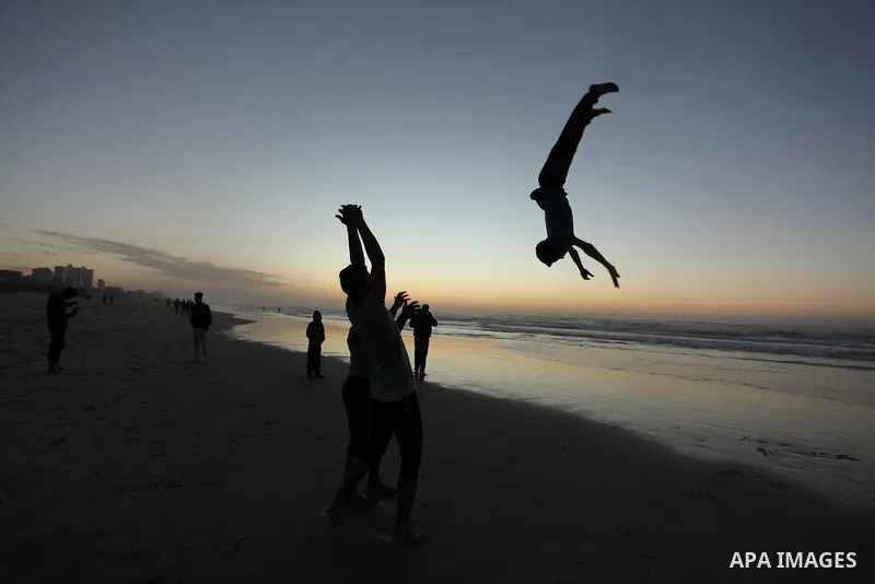 Palestinians enjoy on the beach of Gaza City, during the last sunset of 2016, on December 31, 2016. Photo by Ashraf Amra