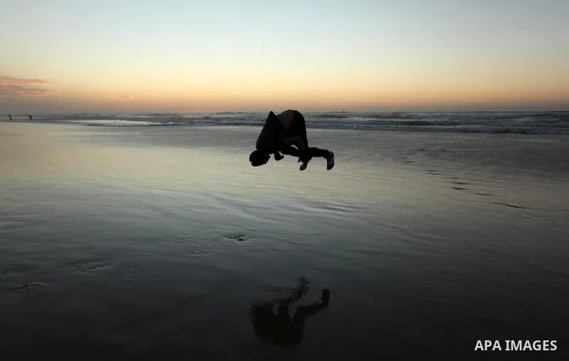 A Palestinian man enjoys on the beach of Gaza City, during the last sunset of 2016, on December 31, 2016. Photo by Ashraf Amra