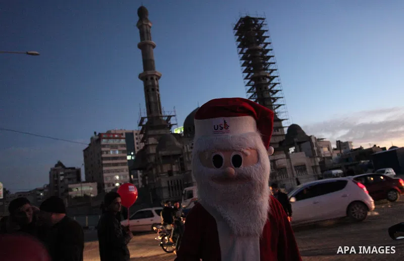 A Palestinian man in Santa Claus costume takes part in the celebration of the New Year at the Gaza seaport, on December 31, 2016. Photo by Ashraf Amra