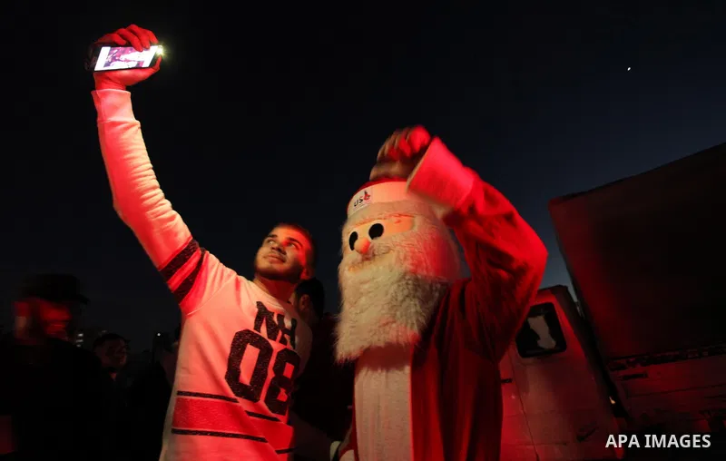 A Palestinian man in Santa Claus costume takes part in the celebration of the New Year at the Gaza seaport, on December 31, 2016. Photo by Ashraf Amra