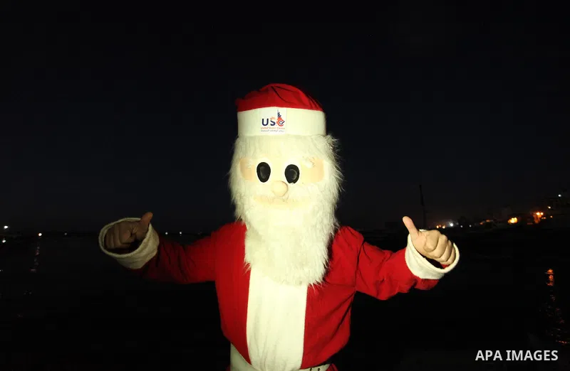 A Palestinian man in Santa Claus costume takes part in the celebration of the New Year at the Gaza seaport, on December 31, 2016. Photo by Ashraf Amra