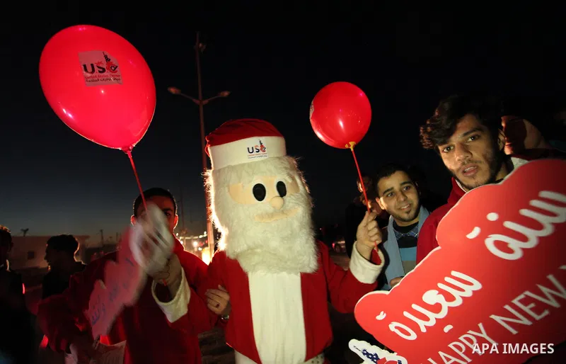 A Palestinian man in Santa Claus costume takes part in the celebration of the New Year at the Gaza seaport, on December 31, 2016. Photo by Ashraf Amra