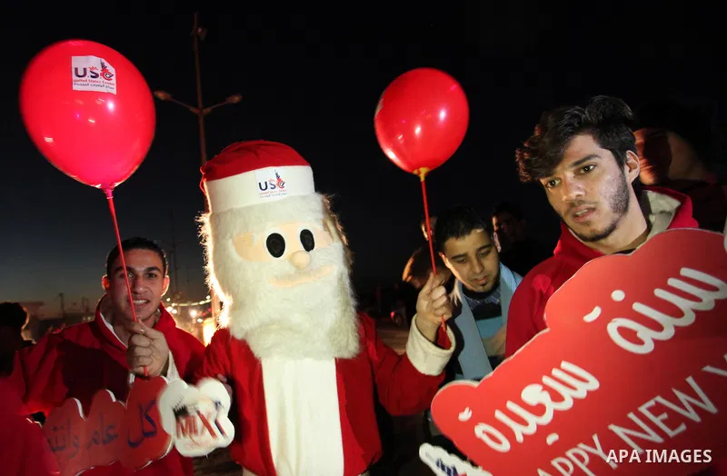 A Palestinian man in Santa Claus costume takes part in the celebration of the New Year at the Gaza seaport, on December 31, 2016. Photo by Ashraf Amra