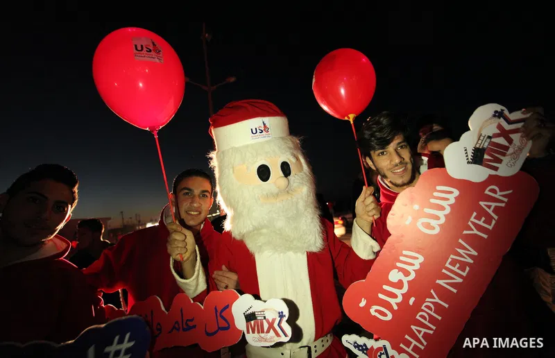 A Palestinian man in Santa Claus costume takes part in the celebration of the New Year at the Gaza seaport, on December 31, 2016. Photo by Ashraf Amra