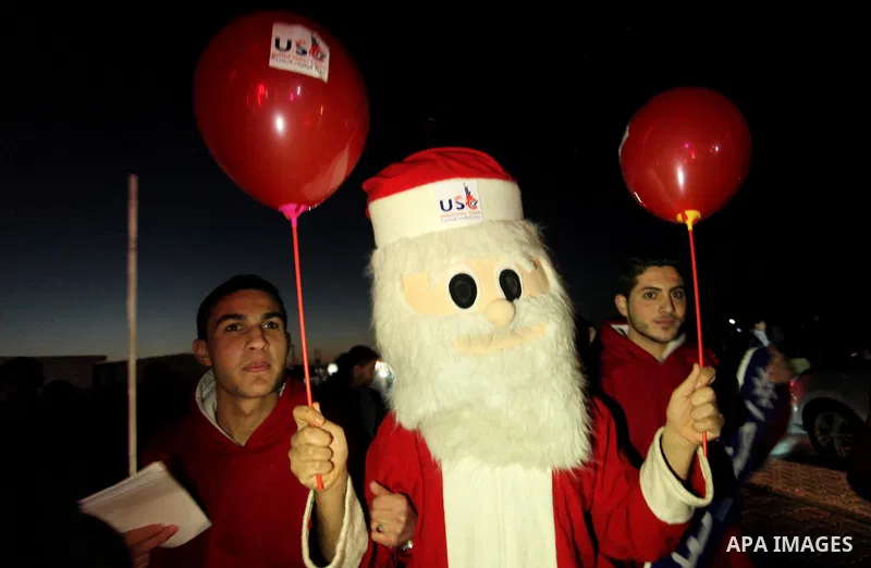 A Palestinian man in Santa Claus costume takes part in the celebration of the New Year at the Gaza seaport, on December 31, 2016. Photo by Ashraf Amra