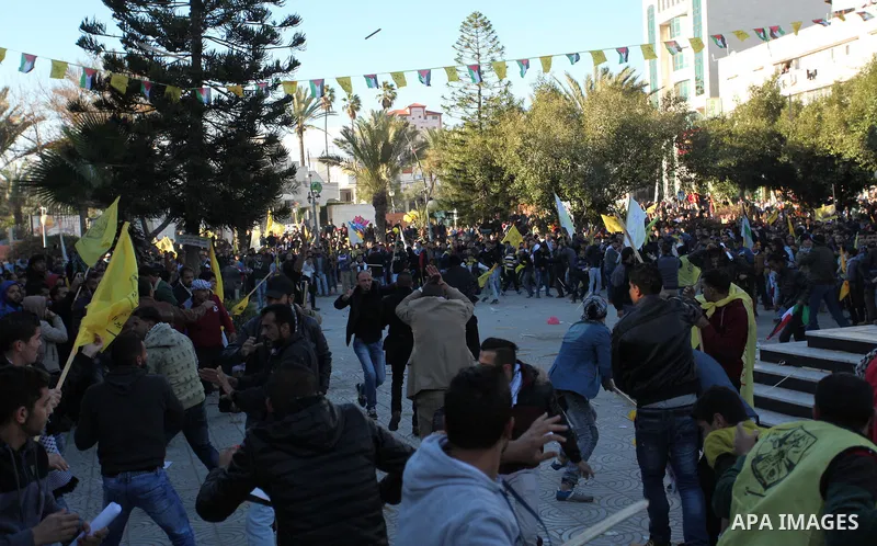 Supporters of the Palestinian president clash with supporters (background) of Mohammed Dahlan, an exiled rival to Mahmud Abbas who was recently sentenced in absentia to three years in prison on corruption charges, during...
