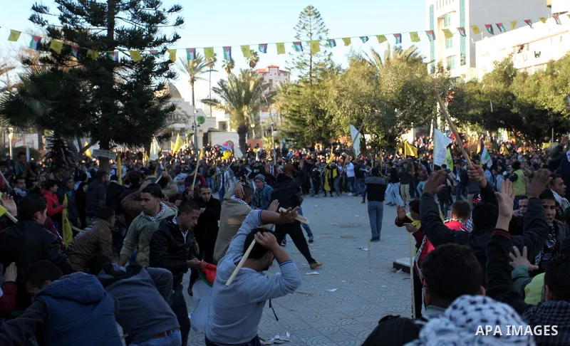 Supporters of the Palestinian president clash with supporters (background) of Mohammed Dahlan, an exiled rival to Mahmud Abbas who was recently sentenced in absentia to three years in prison on corruption charges, during...