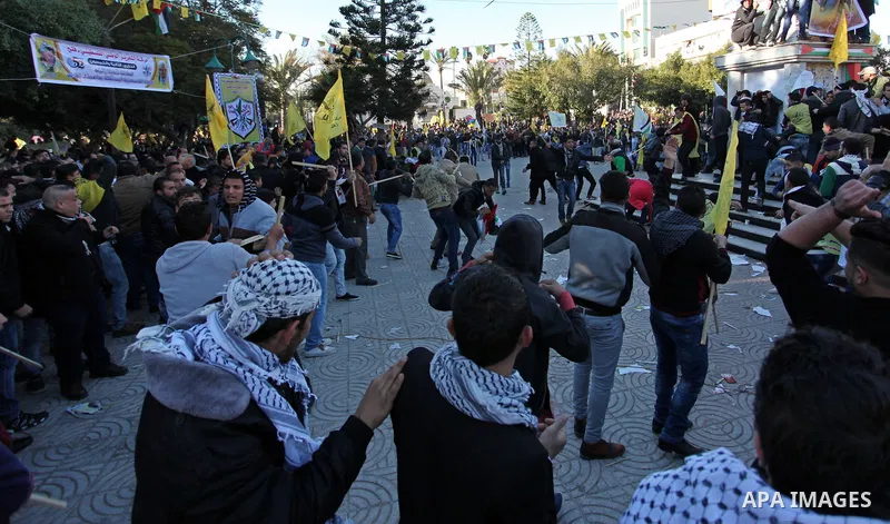Supporters of the Palestinian president clash with supporters (background) of Mohammed Dahlan, an exiled rival to Mahmud Abbas who was recently sentenced in absentia to three years in prison on corruption charges, during...