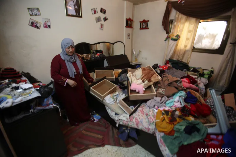 A Palestinian woman inspects the damages at her house after an Israeli military operation, at Balata refugee camp naer in the West Bank city of Nablus, on January 3, 2017. Photo by Nedal Eshtayah