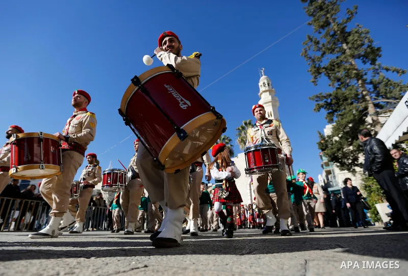 Scouts parade as the Greek Orthodox Patriarch of Jerusalem Theophilos III arrives to celebrate Christmas according to the Eastern Orthodox calendar, outside the Church of the Nativity in the West Bank town of Bethlehem J...