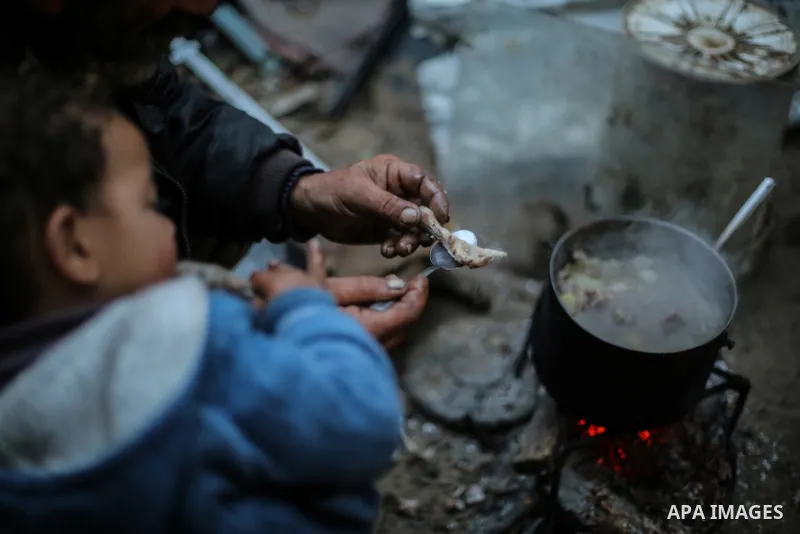 A picture taken on January 5, 2017 shows Palestinian Jamal Shobaki, 51, cooks legged chicken to feed his children in his dwelling on winter season in Khan Younis, in the southern Gaza strip. More than two thirds of the p...