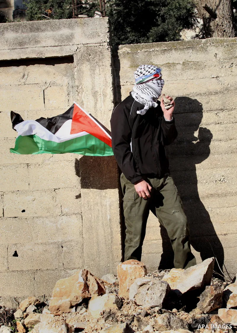 A Palestinian protester carries stones during clashes with Israeli security forces following a demonstration against the expropriation of Palestinian land by Israel in the village of Kfar Qaddum, near Nablus, in the occu...
