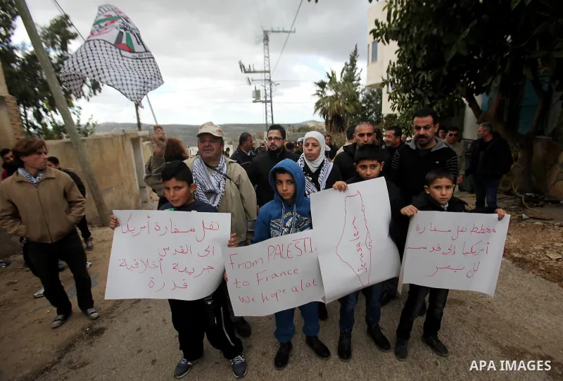 Palestinian children hold placards during a demonstration against the President-elect Donald Trump decision to move the US embassy to Jerusalem, in the village of Kfar Qaddum, near Nablus, in the occupied West Bank on Ja...